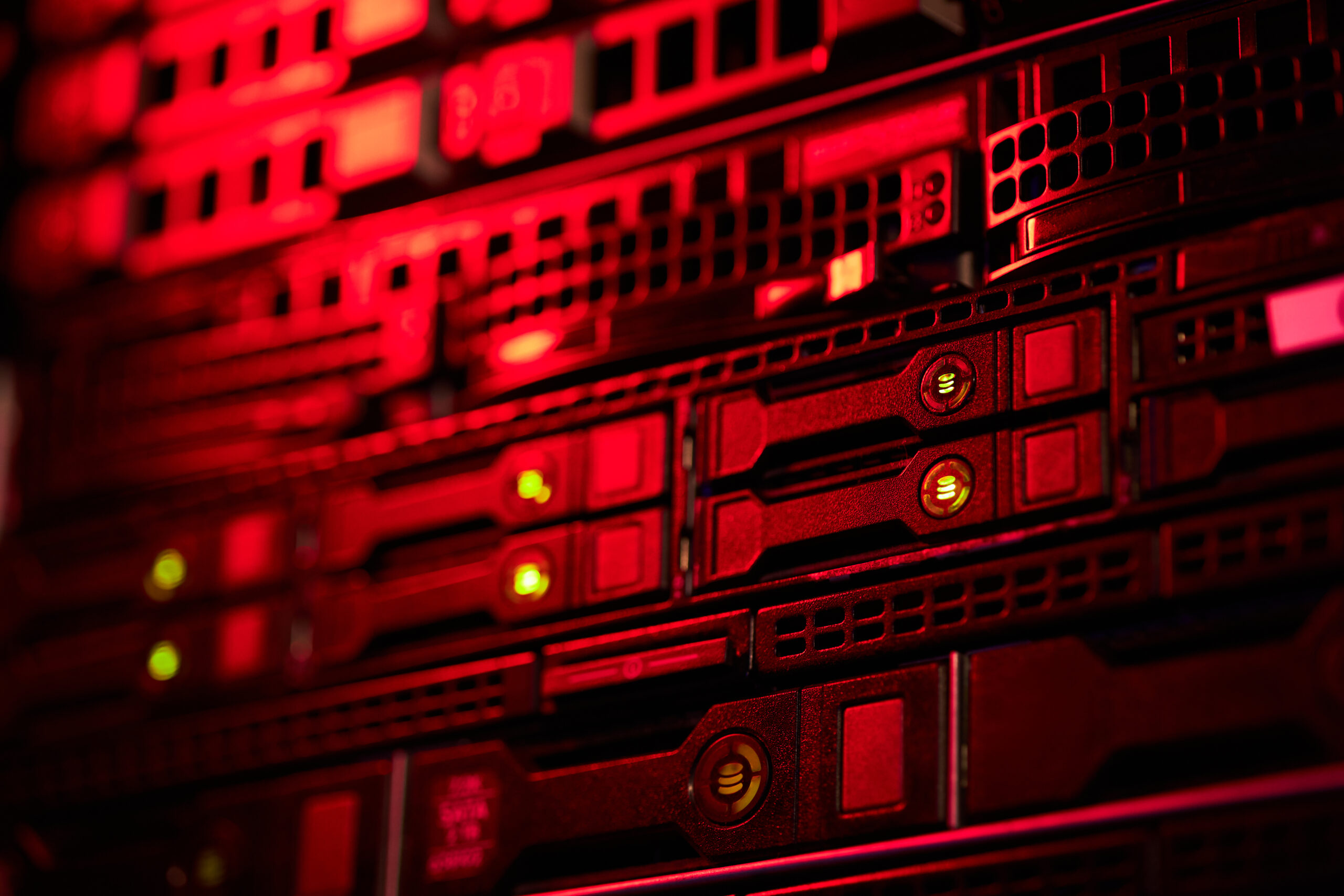 Closeup of high-tech equipment in a data center illuminated with red lighting creating an intense atmosphere. Detailed view of server components emphasizing modern technology