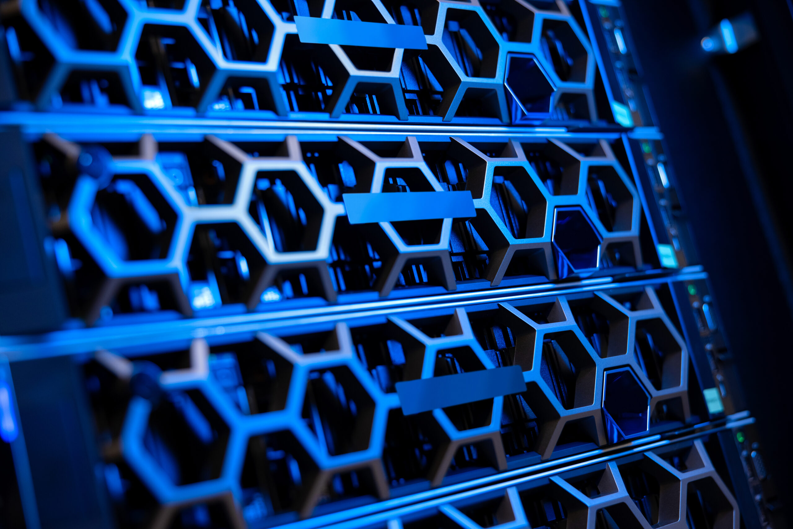 Closeup of illuminated blue SSD hard drives and servers in modern hyperconverged environment datacenter. Large virtual servers and storage.