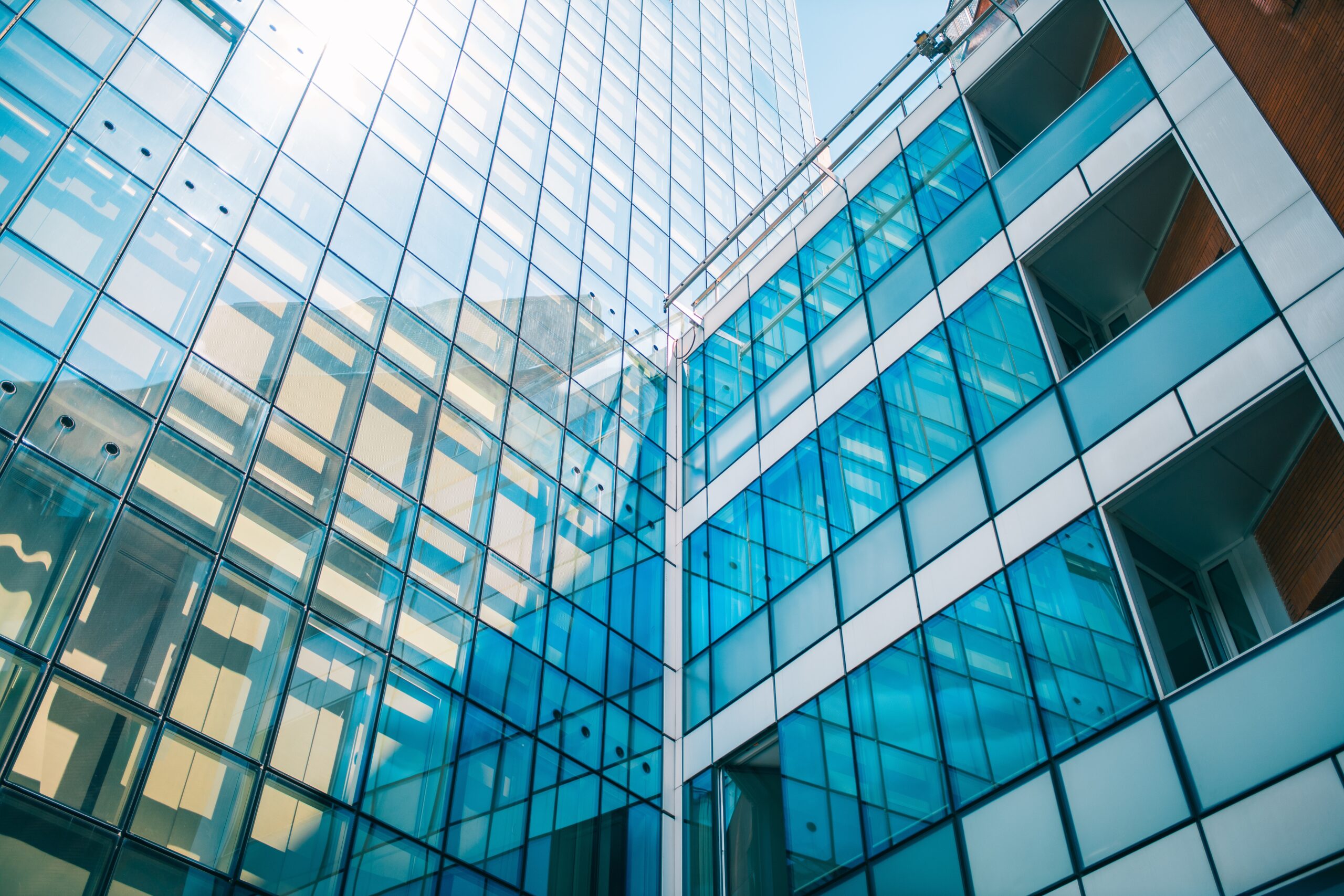 A low angle shot of a business building with glass walls under the sunlight